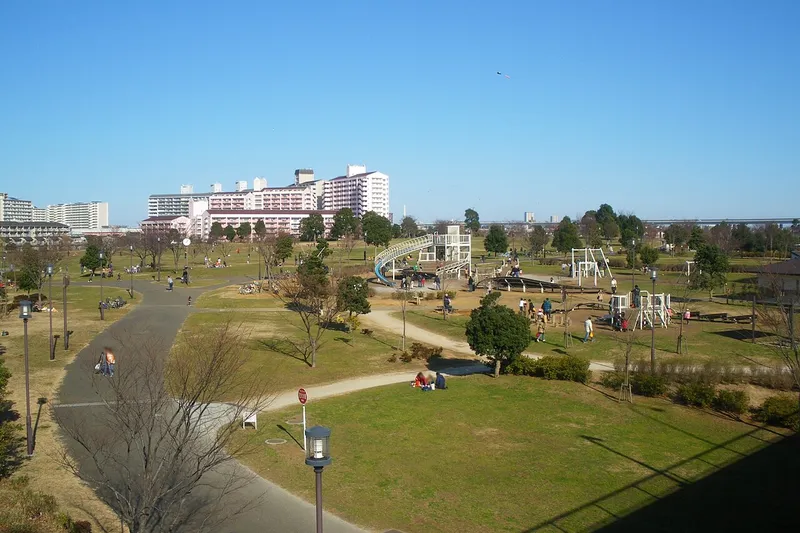 View over the lawn and play equipment of Ojima Komatsugawa Park.